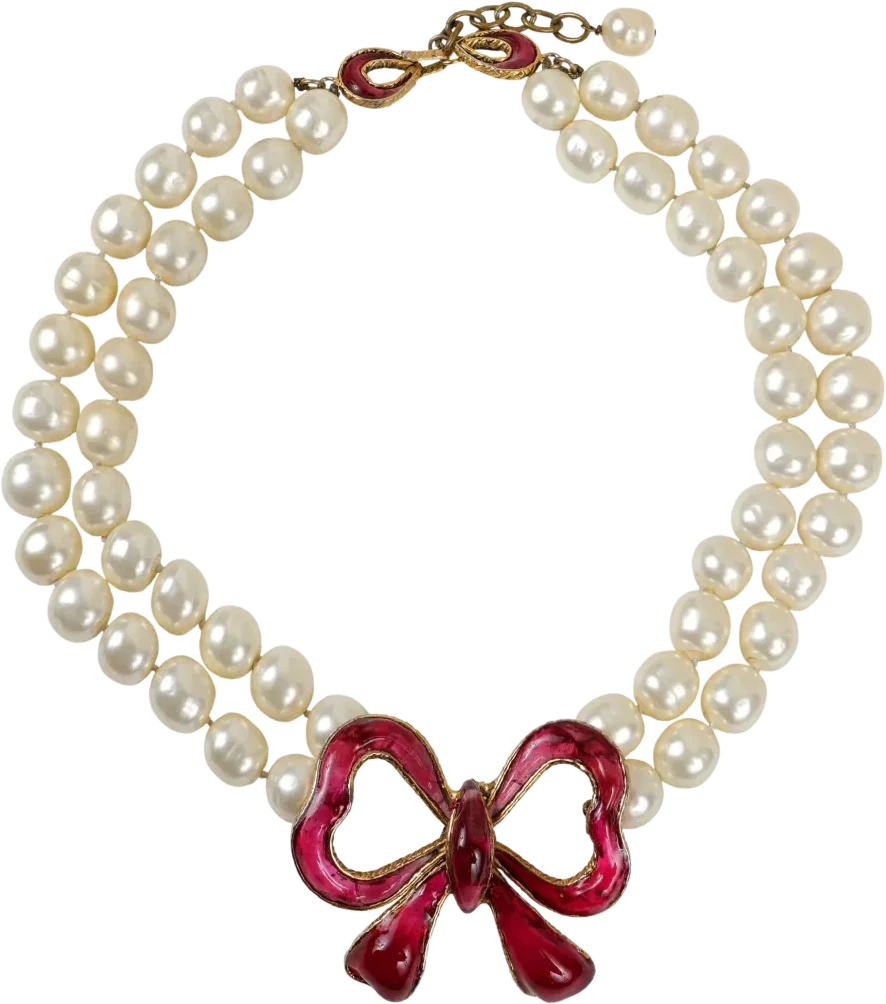 A vintage double strand of pearls closing on a red poured-glass bow.